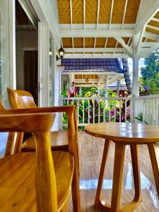 a porch with two tables and chairs on a porch at Jalana Palm Villa in Tabanan
