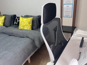 a black and white chair next to a couch at Cafe Sharehouse Kokoro Nest Kyoto in Kyoto