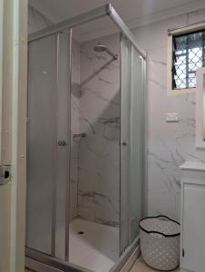 a shower with a glass door in a bathroom at Panatina Hillside 2 bedroom apartment in Honiara