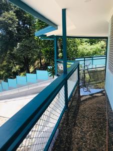 a blue fence on a balcony with blue chairs at Panatina Hillside 2 bedroom apartment in Honiara
