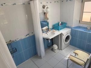 a blue and white bathroom with a washing machine and a sink at Au Bas Chalonge in Ligné
