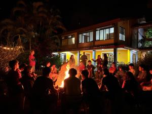 a crowd of people standing around a fire at night at Hotel Honey Bee in Alajuela