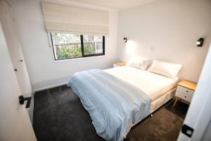 a small bedroom with a bed and a window at Buckley s 10 in Point Lonsdale