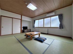 a living room with a table and a window at Hakuba Tsugaike Sunrise Tanne in Otari +43 photos