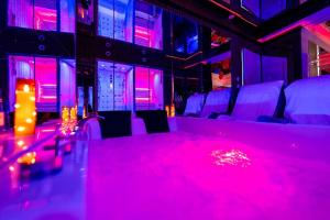 a room with pink lights on the floor and chairs at Le miroir secret in Gien