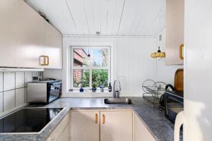 a kitchen with a sink and a window at Cozy Holiday Home Close To Forest And Beach in Hasle