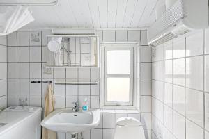 a white bathroom with a sink and a toilet at Cozy Holiday Home Close To Forest And Beach in Hasle +31 photos
