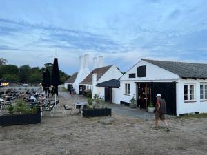 a man walking in front of a white building at Cozy Holiday Home Close To Forest And Beach in Hasle