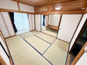 an empty room with wood paneling and windows at アザミヴィラ青島 in Miyazaki