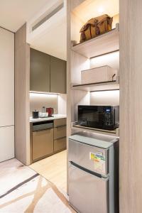 a kitchen with a refrigerator and a microwave at ALVA HOTEL BY ROYAL in Hong Kong