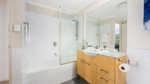 a bathroom with a tub and a sink and a shower at Del Mar 1 in Mandurah +9 photos