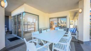 a dining room with a blue table and white chairs at Del Mar 1 in Mandurah