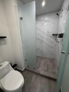 a white bathroom with a toilet and a shower at San Jeronimo Suites in Monterrey