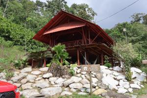 a building with a sign in front of a pile of rocks at LAS 7 CASCADAS Campground - Restaurant - Lodge in Cacaoal