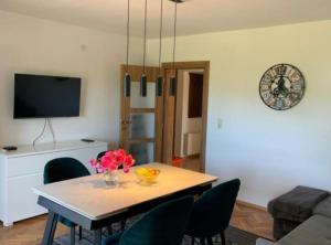 a living room with a table and chairs and a clock at Apartman Ivanka in Imotski
