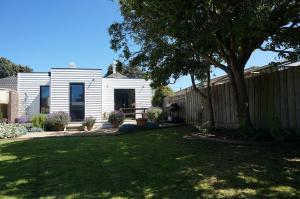a white house with a fence and a yard at Chevignon in Queenscliff