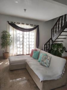 a couch in a living room with a window at Casa com piscina em Aldeia Velha in Quartéis +17 photos
