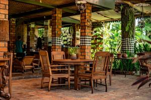 a wooden table and chairs on a patio at Katumbiri Resort and Villa by Tripletree in Bogor