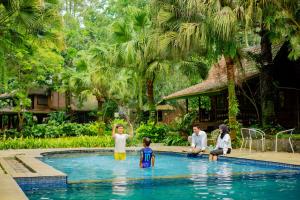 a group of people sitting around a swimming pool at Katumbiri Resort and Villa by Tripletree in Bogor