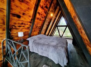 a bed in a room with a large window at Cabañas Bosque Antiguo in Tapalpa