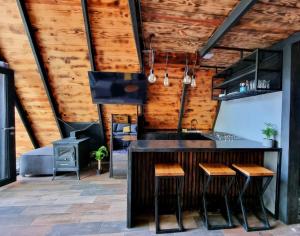 a kitchen with a bar and wooden walls at Cabañas Bosque Antiguo in Tapalpa
