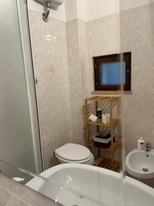 a bathroom with a toilet and a sink and a television at Casa Rossa in Ferentillo