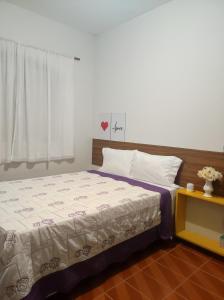 a bedroom with a bed and a window and a table at Casa com piscina em Aldeia Velha in Quartéis