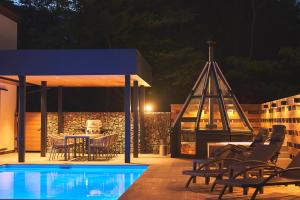 a patio with a table and chairs next to a pool at Villa Saison Fuji ヴィラ セゾン フジ in Fujikawaguchiko