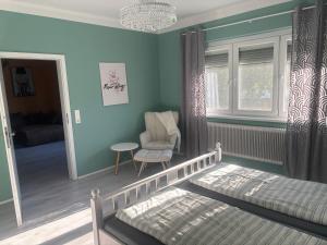 a bedroom with a bed and a chair and a window at Haus 4 you in Winden am See