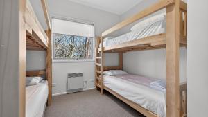 a bedroom with two bunk beds and a window at Alpenglow in Dinner Plain