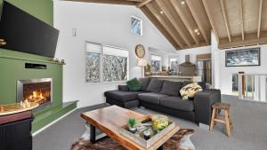 a living room with a couch and a fireplace at Alpenglow in Dinner Plain