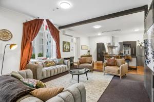 a living room with two couches and a table at Chapel On Moray - Apartment in Dunedin