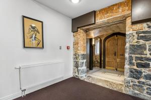 a living room with a stone fireplace and a brick wall at Chapel On Moray - Apartment in Dunedin
