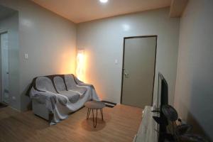 a living room with a couch and a television at RSGH Staycation in Biñan