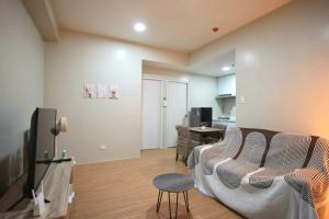 a living room with a couch and a table at RSGH Staycation in Biñan