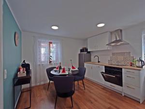 a kitchen with a table and chairs in a kitchen at JIRVISTA-Homes, voll ausgestattete Wohnung im EG, kontaktloser Zutritt in Burghausen