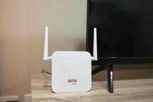 a white router sitting next to a tv at RSGH Staycation in Biñan