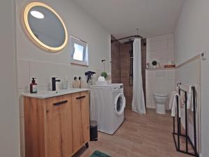 a bathroom with a sink and a washing machine at JIRVISTA-Homes, voll ausgestattete Wohnung im EG, kontaktloser Zutritt in Burghausen