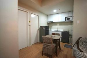 a small kitchen with a table and chairs in a room at RSGH Staycation in Biñan
