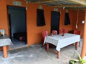 a table and chairs in a room with an orange wall at Wale Chika Guest House in Tomohon