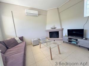 a living room with a couch and a fireplace at Schinias Forest Beach House in Marathon