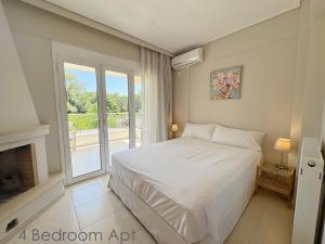 a bedroom with a white bed and a fireplace at Schinias Forest Beach House in Marathon