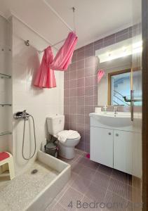 a pink bathroom with a toilet and a sink at Schinias Forest Beach House in Marathon +47 photos