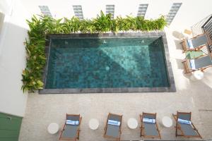 an overhead view of a swimming pool with chairs and plants at Nagomi Studio Nyanyi in Cemagi
