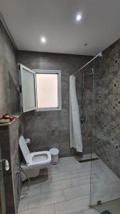 a bathroom with a toilet and a glass shower at Excellent Appartement S plus 3 in Kelibia +17 photos