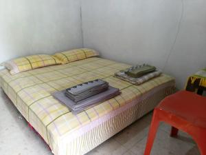 a small bed with two pillows and towels on it at Wale Chika Guest House in Tomohon