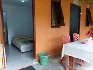 a room with a bed and a table and chairs at Wale Chika Guest House in Tomohon +9 photos