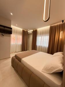 a bedroom with a large bed in front of windows at Hotel Alga Velipoje in Velipojë +57 photos