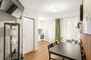 a living room with a table and a kitchen at BERG & BERG Apartments - Luzern Self-Check-in in Lucerne