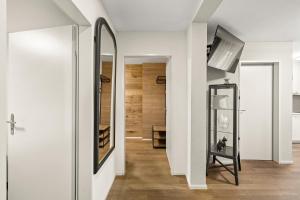 a hallway with white walls and a mirror at BERG & BERG Apartments - Luzern Self-Check-in in Lucerne
